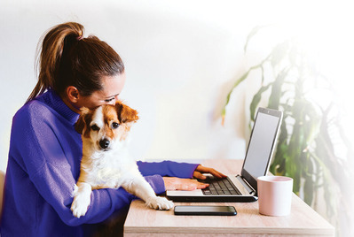girl with dog at laptop